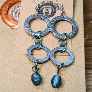 Earrings crafted from the outer rim of authentic 1 and 5 Nuevo Peso coins with an iridescent bead. A great gift thats handmade and unique