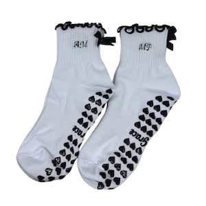 Custom initial black and white grip socks with bow and heart grips, perfect for Pilates, Yoga, Barre or lagree