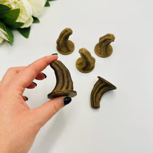 May include: Five brown, 3D printed, horn-shaped objects. The horns are approximately 5 cm tall and have a textured surface.