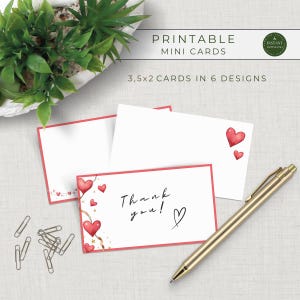 May include: Printable mini cards with a red border and heart designs. One card says "Thank you!" with a heart symbol. The cards are 3.5 x 2 inches in size. A gold pen and paper clips are also in the image.