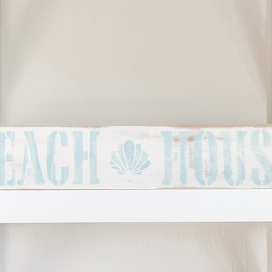 Handgemaakt bord met verweerd strandhuis: Decor van een boerderij aan de kust