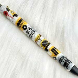 Peut inclure: Un stylo noir et jaune pailleté avec les mots "Bus Driver" et un dessin de bus scolaire.
