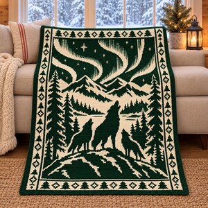 Peut inclure: Une couverture en tricot vert foncé et crème présentant un motif central de trois loups hurlant face à une chaîne de montagnes sous un ciel étoilé avec des aurores boréales, encadrée par une bordure de motifs de sapins.