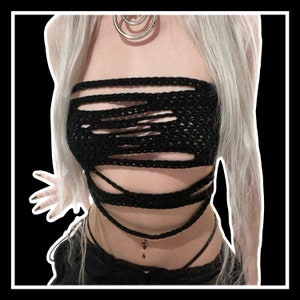Peut inclure: Un haut en crochet noir avec un design ajouré et délavé. Le haut est porté comme un bandeau et présente des détails de bretelles croisées.