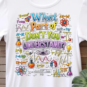 Könnte beinhalten: Weißes T-Shirt mit einem farbenfrohen, wissenschaftlichen Motiv. Das Design umfasst Gleichungen, eine Rakete und den Text "What Part of DON'T YOU UNDERSTAND?" Das T-Shirt hängt an einem Holzbügel.