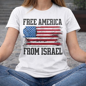 May include: White t-shirt featuring a distressed American flag design with the text "FREE AMERICA FROM ISRAEL" in black. The flag design includes red and white stripes and a blue field of stars.
