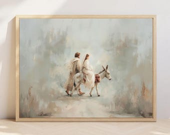 May include: A framed print depicts a religious scene. Two figures, one walking and the other riding a donkey, are rendered in soft, muted tones of beige, white, and gray. The artwork is set against a textured, light-colored background, framed in a light wood.