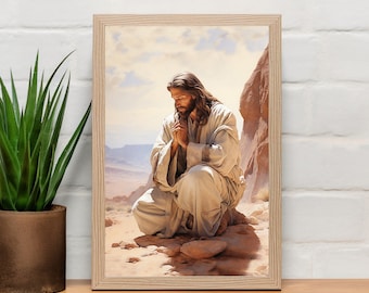 May include: A framed painting of a man kneeling in prayer with his hands clasped together. He is wearing a white robe and has long brown hair and a beard. The background is a desert landscape with rocky cliffs.