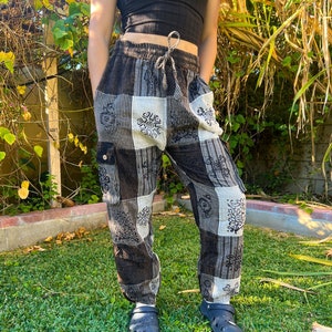 May include: Black and white patterned pants with a drawstring waist and cargo pockets. The pants are made of a soft, comfortable fabric and have a relaxed fit.