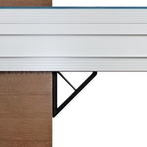 Op de afbeelding: Close-up van een witte metalen plankbeugel met een zwarte driehoekige steun. De beugel is bevestigd aan een houten oppervlak.