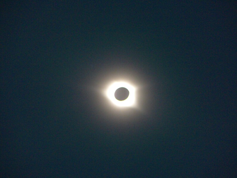 May include: A total solar eclipse, with the moon completely blocking the sun, creating a bright ring of light around the moon's silhouette.