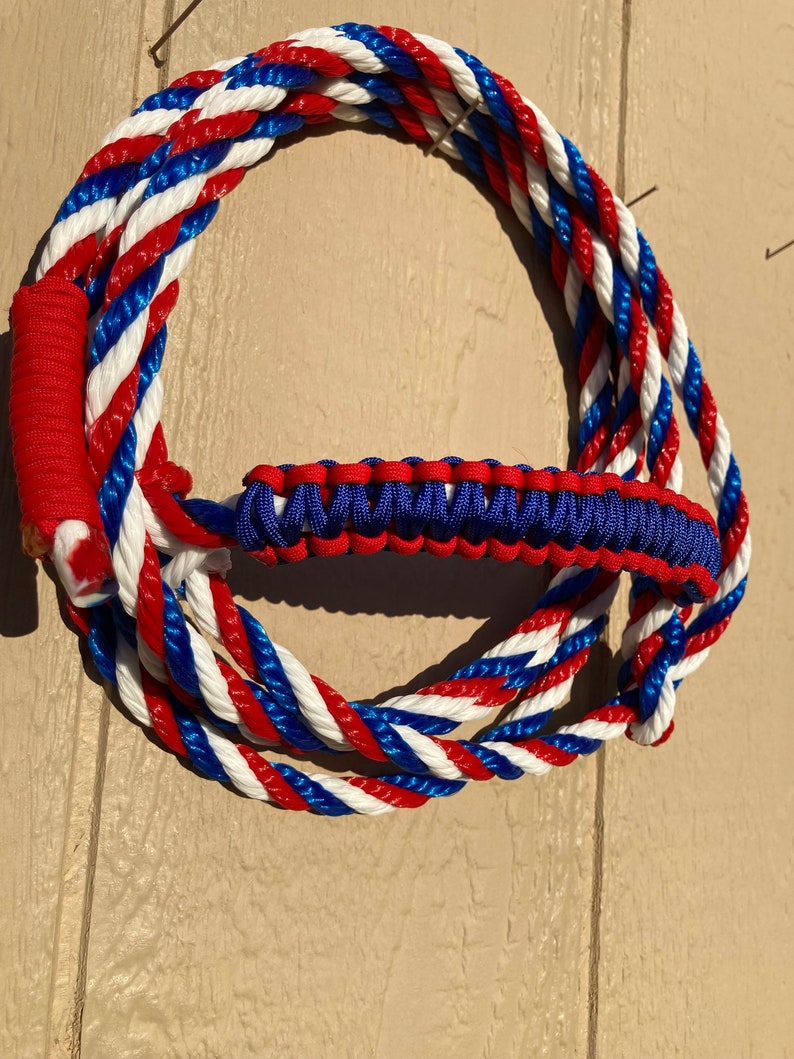 May include: A red, white, and blue braided rope with a matching braided handle. The rope is coiled into a circle.