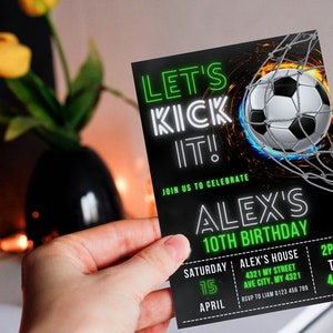 May include: Black and green birthday invitation with neon green text that reads "Let's Kick It!" and "Alex's 10th Birthday". The invitation features a soccer ball in a net with flames behind it. The invitation includes the date, time, and location of the party.