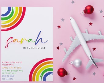 Może przedstawiać: Zaproszenie urodzinowe z tęczowym wzorem i imieniem "Sarah" w kolorowym skrypcie. Zaproszenie zawiera tekst "IS TURNING SIX" oraz szczegóły wydarzenia. Zabawkowy samolot, czerwone i srebrne bombki oraz konfetti w kształcie gwiazd ułożone na różowej powierzchni.