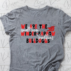 May include: Gray t-shirt with red and black text that reads "We Are The Small Town Winder-Barrow Traditions Bulldogs". The text is in a bold, blocky font. There is a red and white "WB" logo above the text.