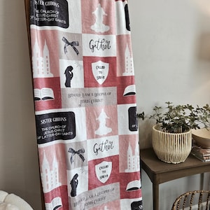 May include: A pink and white fleece blanket with a patchwork design featuring a temple, a woman praying, a shield with the words "Called to Serve", and the text "Gather" and "Behold, I am a disciple of Jesus Christ".