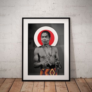 May include: Black and white photo of a man with a red circle around his head. He is wearing a chain necklace and a patterned skirt. He is holding a microphone.