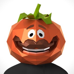 May include: A red and green papercraft tomato with a smiling face, a mustache, and white teeth. The tomato is wearing a black shirt.