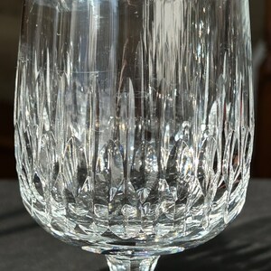 Puede incluir: Una copa de vidrio transparente con un dise&ntilde;o de cristal tallado. La copa tiene una copa ancha y un tallo alto.