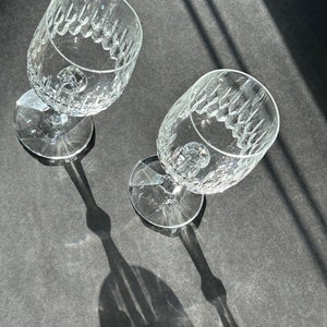 Puede incluir: Dos copas de vino de vidrio transparente con un patr&oacute;n de diamante en la superficie. Las copas est&aacute;n vac&iacute;as y est&aacute;n sobre una superficie gris.