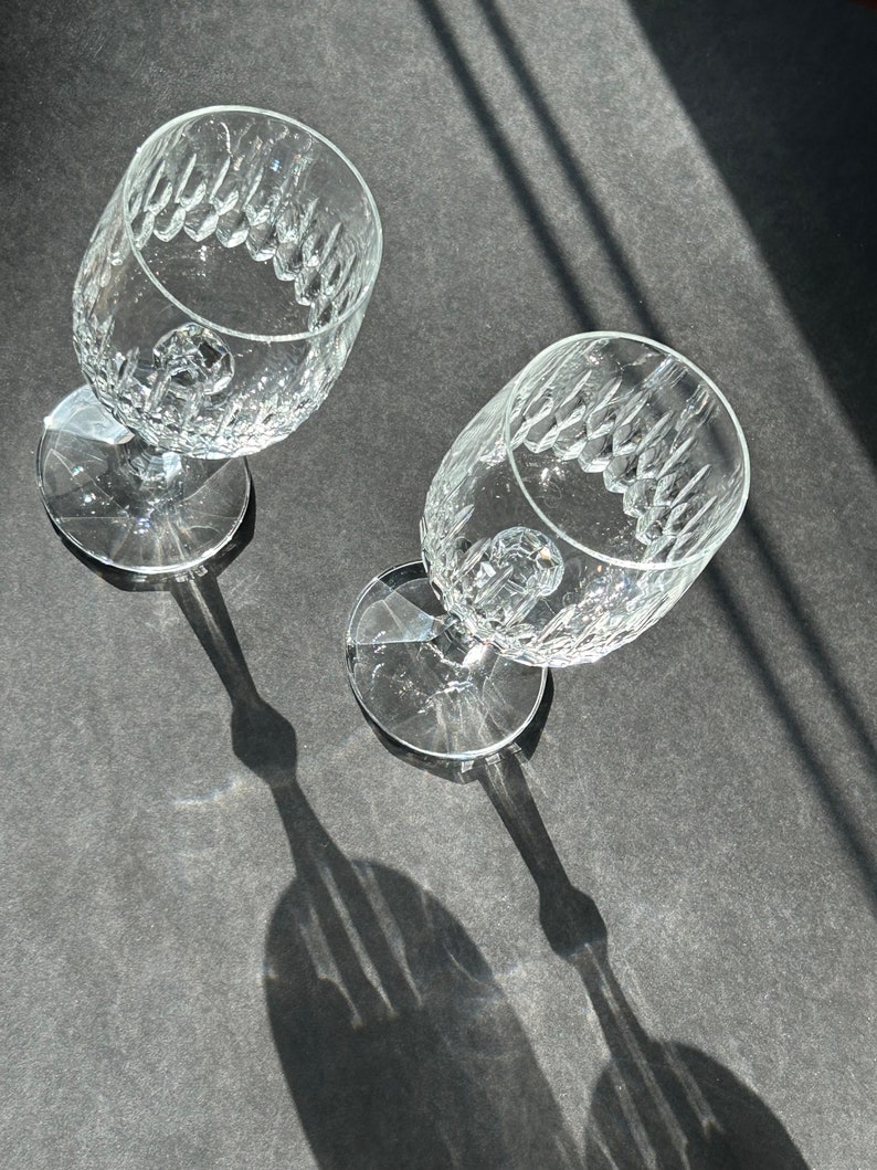 Puede incluir: Dos copas de vino de vidrio transparente con un patr&oacute;n de diamante en la superficie. Las copas est&aacute;n vac&iacute;as y est&aacute;n sobre una superficie gris.