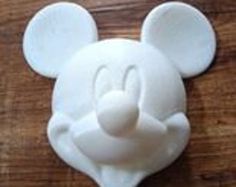 Puede incluir: Molde de plástico blanco de la cabeza de Mickey Mouse, con sus características orejas, nariz y sonrisa. Este molde es perfecto para crear manualidades o decoraciones personalizadas.