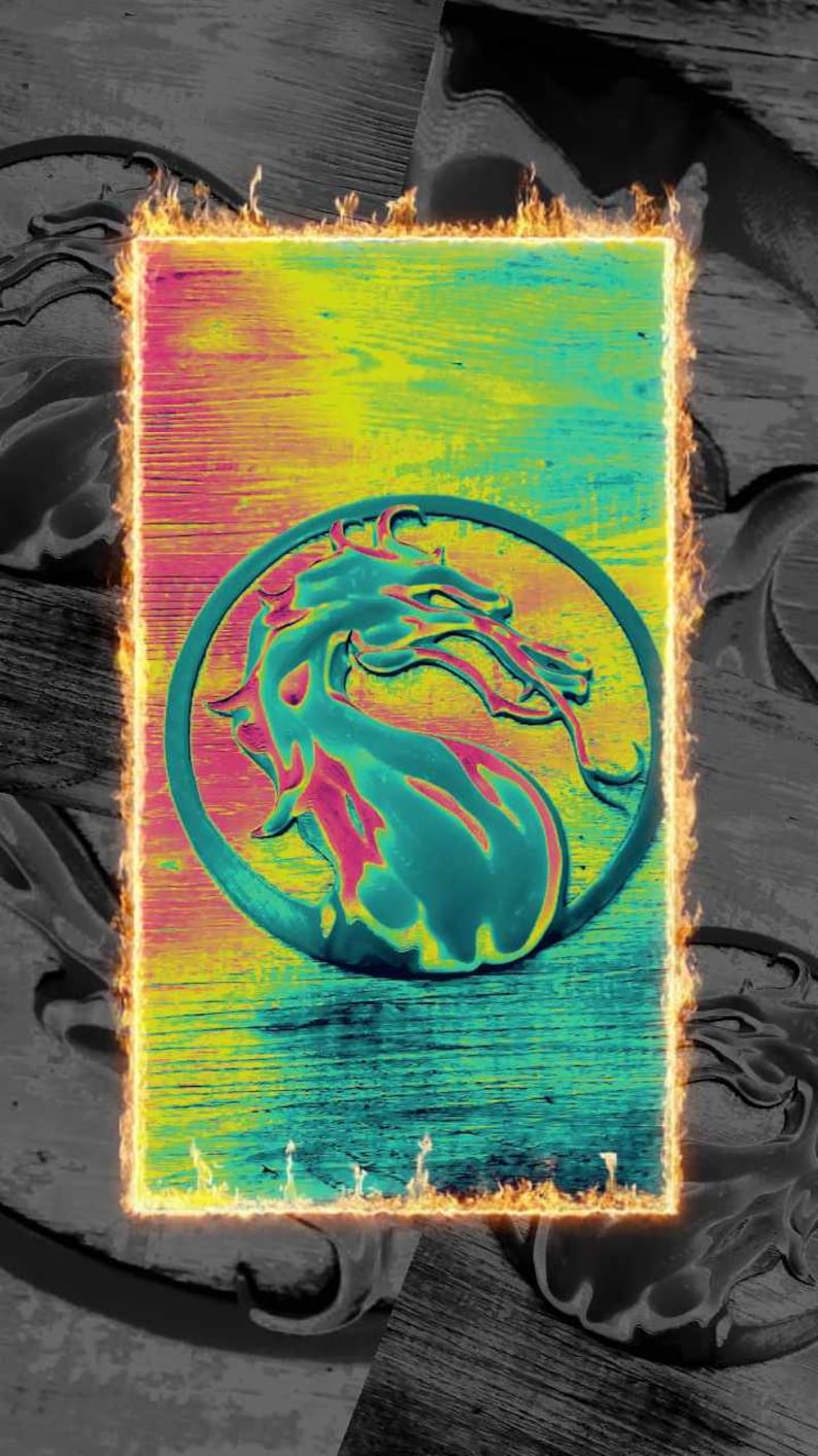 May include: A fiery orange and yellow frame surrounds a green, yellow, and pink dragon logo on a wooden background.