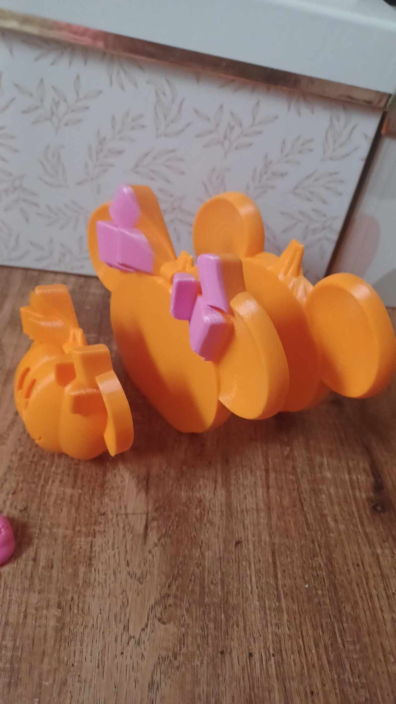 May include: Orange and pink plastic toy shaped like a cartoon character with large ears. The toy is in two pieces, one of which is a separate head.