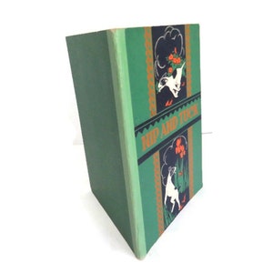 May include: A green hardback book with the title "Rip and Tuck" on the spine. The cover features black and white illustrations of dogs with orange flowers.