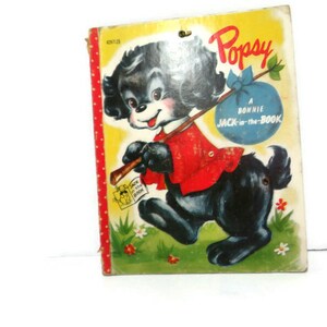 May include: A vintage children's book cover featuring a cartoon black dog named "Popsy" carrying a blue bag. The book title is "A Bonnie Jack-in-the-Book".