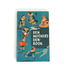 May include: A blue book with the title "The Den Mother's Den-Book" and illustrations of children in scout uniforms.