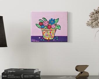 May include: A colorful painting of a potted plant with pink, blue, and yellow flowers. The pot is a checkered pattern of green, yellow, orange, and pink. The background is a light pink with a purple stripe at the bottom.