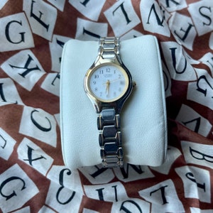 classic two-tone Citizen 1012-S072697 watch with a round case, white dial, date window, gold hands