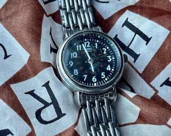 retro vintage silver Timex watch with a round circle case and black dial, white and red accents