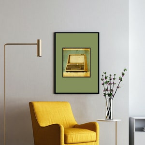May include: A yellow armchair sits in a living room with a framed print of a vintage computer keyboard on the wall. A floor lamp with a gold finish stands next to the chair. A vase with pink flowers sits on a small table.