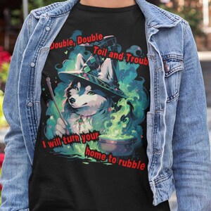 May include: Black t-shirt with a graphic of a wolf wearing a witch's hat and holding a wand and a cauldron. The text on the shirt reads "Double, Double Toil and Trouble I will turn your home to rubble."