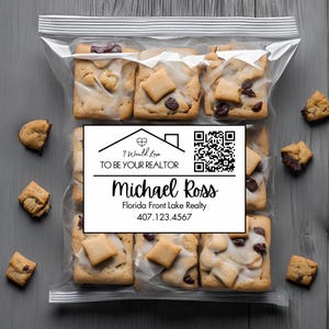 May include: A clear plastic bag containing square cookies with chocolate chips and white icing. A white label features a house icon, a QR code, and the text: I Would Love TO BE YOUR REALTOR, Michael Ross, Florida Front Lake Realty, 407.123.4567.