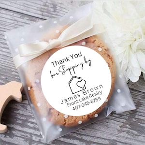 May include: White round sticker with black text that says "Thank You for Stopping by" with a house icon and a heart inside. Below the icon is the text "James Brown Front Lake Realty 407-345-6789".