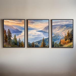 Könnte beinhalten: Set aus drei gerahmten Aquarell-Landschaftsbildern. Jedes zeigt eine ruhige Berg- und Seeszene mit Bäumen im Vordergrund. Die Farbpalette umfasst Blau-, Orange- und Grüntöne und erzeugt eine natürliche Ästhetik. Die Rahmen sind schwarz.