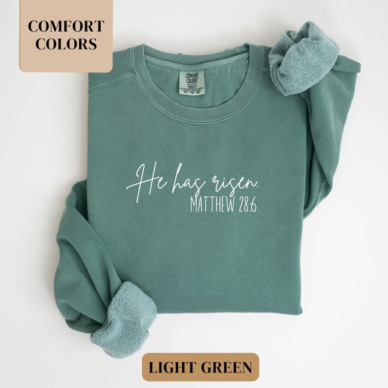 May include: Light green sweatshirt with the text "He has risen. Matthew 28:6" in white.