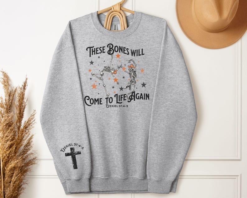 May include: Gray sweatshirt with a graphic of two skeletons dancing with stars and the text "These bones will come to life again Ezekiel 37:4-5".