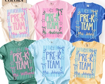 May include: Five short-sleeved t-shirts in cream, pink, blue, green, and yellow. Each shirt features a vertical striped rectangle, the text PRE-K TEAM, stars, and bows. Below the design, each shirt displays a unique name: Mrs. Smith, Ms. Anderson, Mrs. Johns, Mrs. Williams, and Mrs. Johnson.