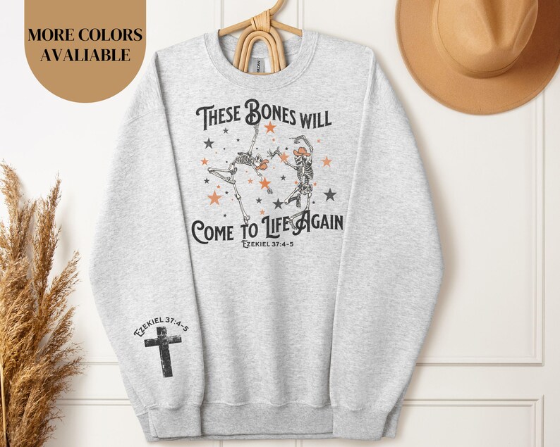 May include: Gray sweatshirt with a graphic of two skeletons dancing with the text "These bones will come to life again Ezekiel 37:4-5".