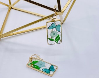 Oorbellen met blauwe harsbloem: vergulde hanger met gedroogde bloemen