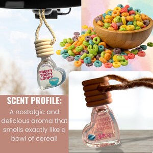 K&ouml;nnte beinhalten: Ein herzf&ouml;rmiger Auto-Lufterfrischer mit einer Schnur zum Aufh&auml;ngen. Der Lufterfrischer ist mit einer klaren Fl&uuml;ssigkeit gef&uuml;llt und tr&auml;gt ein Etikett mit der Aufschrift "FRUITY TOOTY LOOPY". Der Lufterfrischer h&auml;ngt an einem R&uuml;ckspiegel. Das Bild zeigt auch eine Sch&uuml;ssel mit buntem M&uuml;sli.