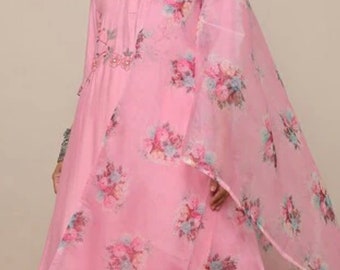 May include: A pink floral print kurta with a matching dupatta and pants. The kurta has a high neck and a button closure. The dupatta is sheer and has a floral print. The pants are plain pink.