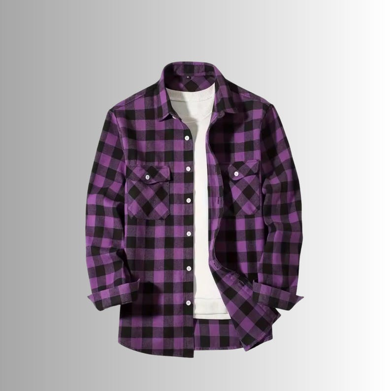 May include: A purple and black plaid flannel shirt with two chest pockets and a button-down front. The long-sleeved shirt is shown over a white t-shirt. The cuffs are rolled up.