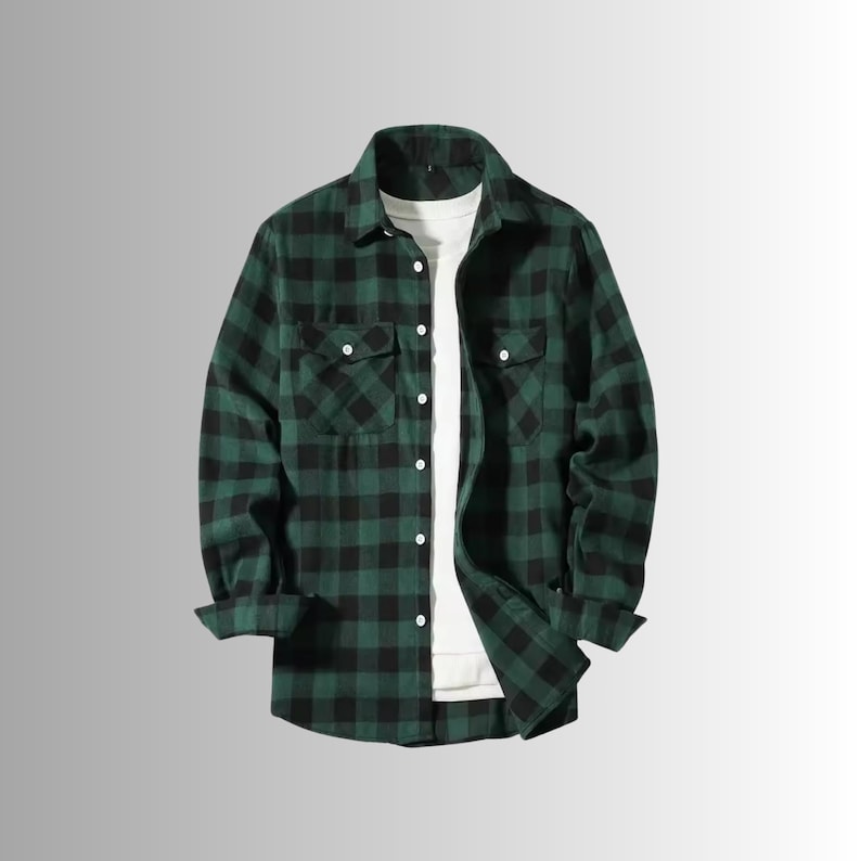May include: A green and black plaid flannel shirt with two chest pockets and white buttons. The long-sleeved shirt is unbuttoned, revealing a white t-shirt underneath. The shirt is a casual style.