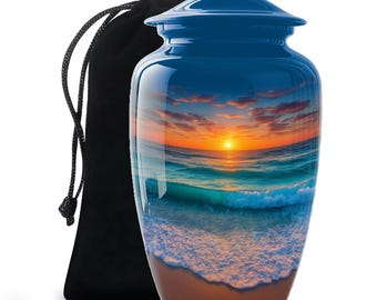 May include: A blue metal cremation urn featuring a glossy finish with a printed sunset beach scene showing ocean waves crashing onto a sandy shore. The urn has a matching blue lid and is accompanied by a black velvet drawstring storage bag.