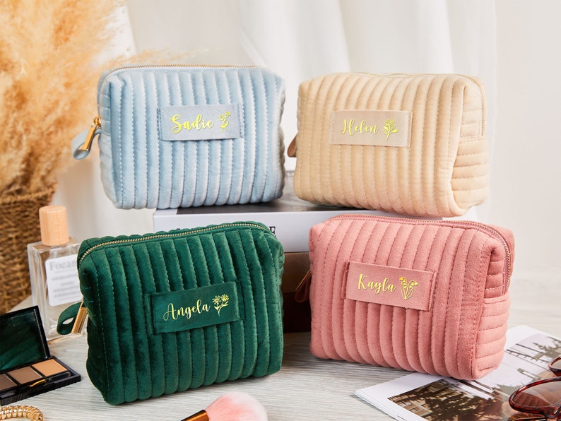 May include: Four quilted velvet cosmetic bags with gold zipper pulls and personalised names. The bags are in blue, beige, green, and pink.